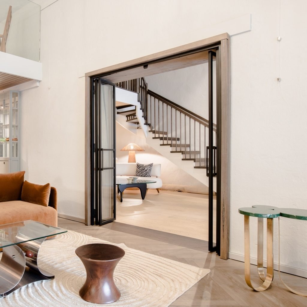Foldedør i klart glass og metall brukt som elegant romdeler i moderne leilighet