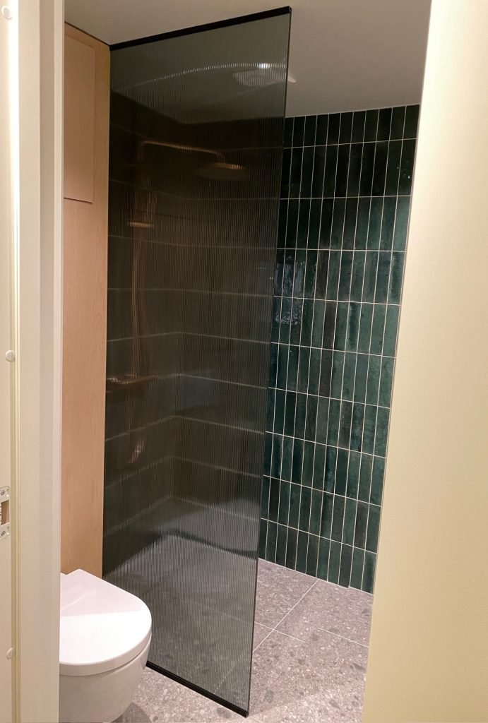 Dusjvegg rammeløs med glass og rillet design