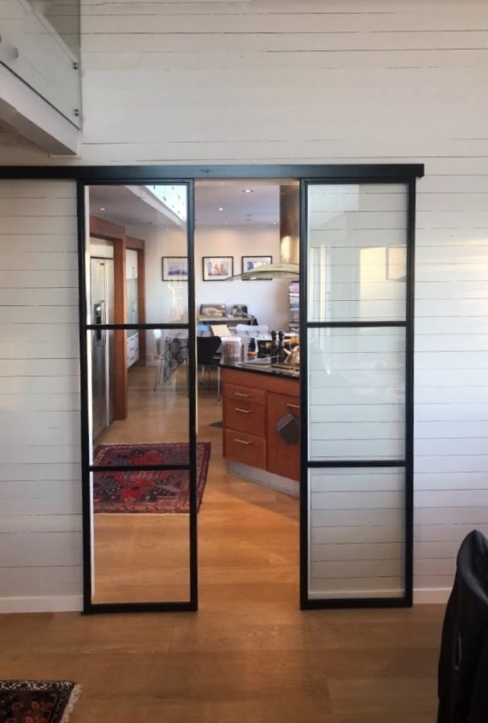 Skyvedør i metall og glass med utenpåliggende installasjon