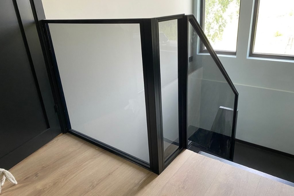 Moderne rekkverk i metall med laminert glass.