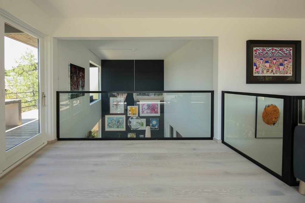 Svart metallramme med glassrekkverk stilfull og robust.