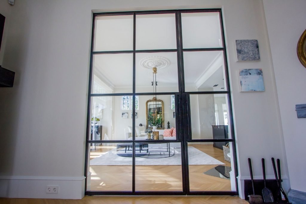 Skyvedør integrert i veggen med metallramme og glass – praktisk og elegant design for effektive rominndelinger.